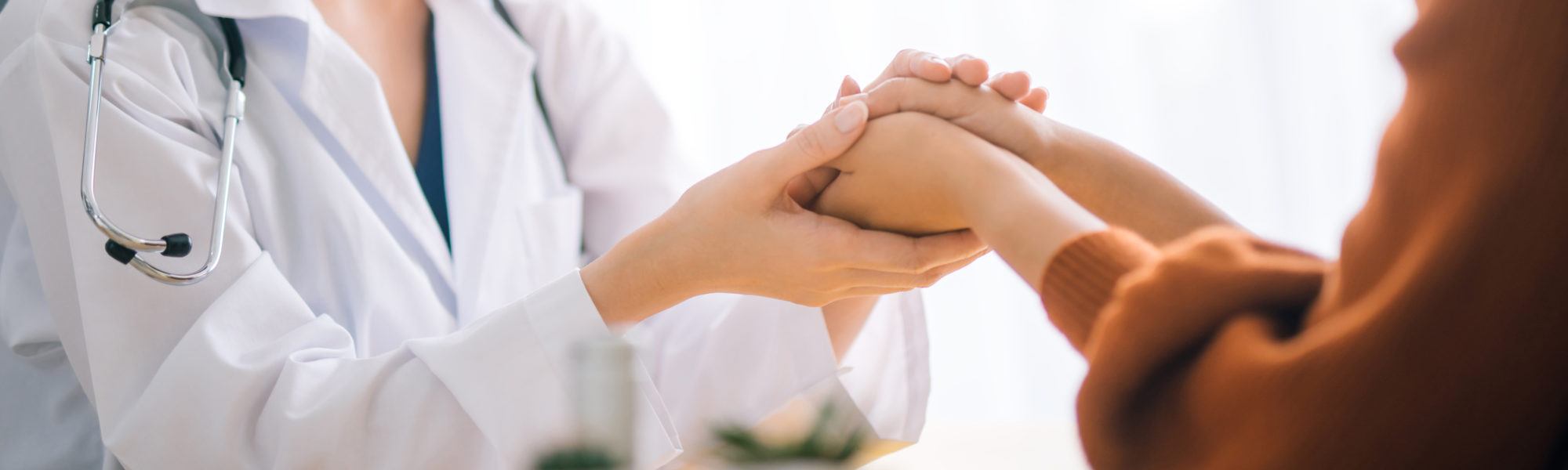 Doctor holding regenerative medicine patient's hand as reassurance